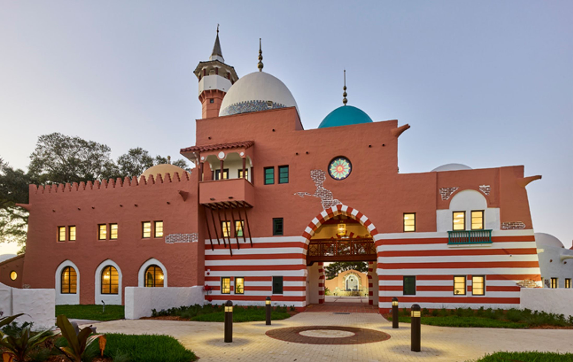 Opa-locka's Moorish Revival City Hall with domes, arches, and palm trees at sunset